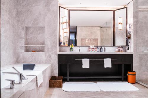 a bathroom with two sinks and a large mirror at Yuexiu Hotel Guangzhou,Curio Collection by Hilton-Free shuttle between hotel and Exhibition Center during Canton Fair & Exhibitor Registration Counter in Guangzhou