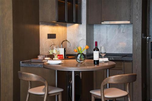 a kitchen with a table with two chairs and a bottle of wine at Yuexiu Hotel Guangzhou,Curio Collection by Hilton-Free shuttle between hotel and Exhibition Center during Canton Fair & Exhibitor Registration Counter in Guangzhou
