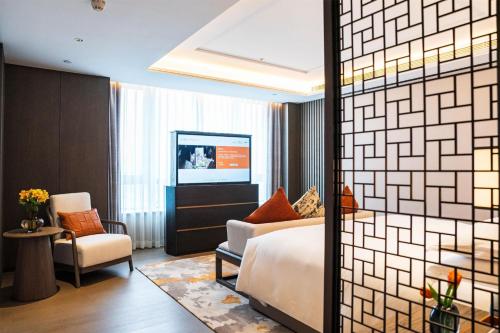 a hotel room with a bed and a chair at Yuexiu Hotel Guangzhou,Curio Collection by Hilton-Free shuttle between hotel and Exhibition Center during Canton Fair & Exhibitor Registration Counter in Guangzhou