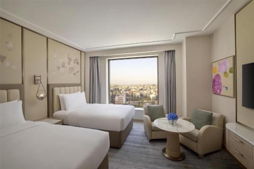 a hotel room with two beds and a window at Signia by Hilton in Amman