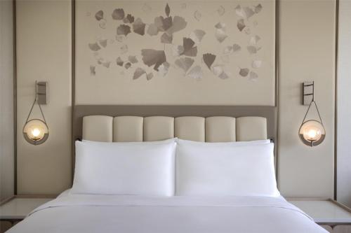 a bedroom with a bed with two lights above it at Signia by Hilton in Amman