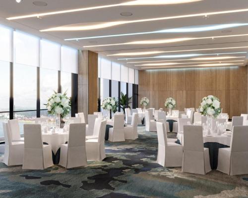 a banquet hall with white tables and white chairs at Hyatt Place Ha Long Bay, Bai Chay in Ha Long