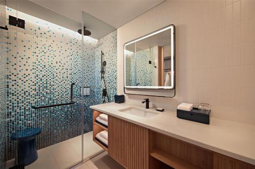 a bathroom with a sink and a shower with a mirror at Hyatt Place Ha Long Bay, Bai Chay in Ha Long
