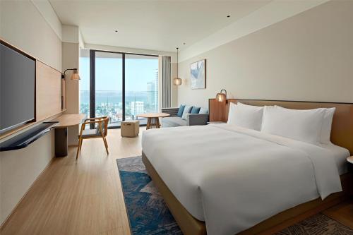 a hotel room with a large bed and a television at Hyatt Place Ha Long Bay, Bai Chay in Ha Long