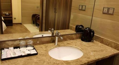 a bathroom counter with a sink and a mirror at Hanyong Hotel Shenzhen International Exhibition Center in Shenzhen