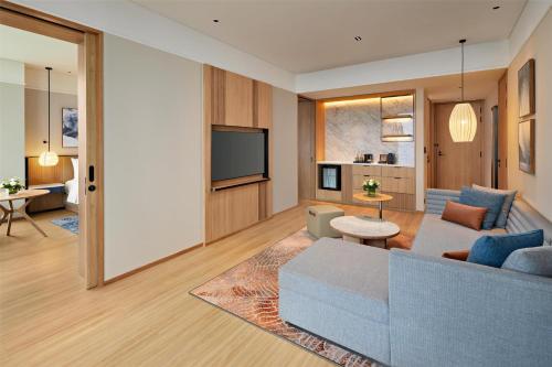 a living room with a couch and a tv at Hyatt Place Ha Long Bay, Bai Chay in Ha Long