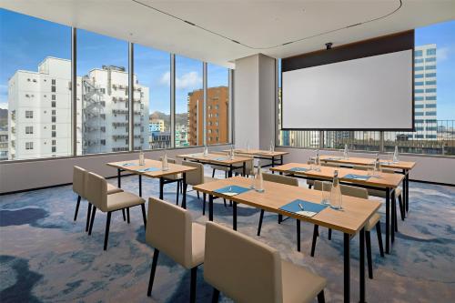 a conference room with tables and chairs and a large screen at Hyatt Place Ha Long Bay, Bai Chay in Ha Long