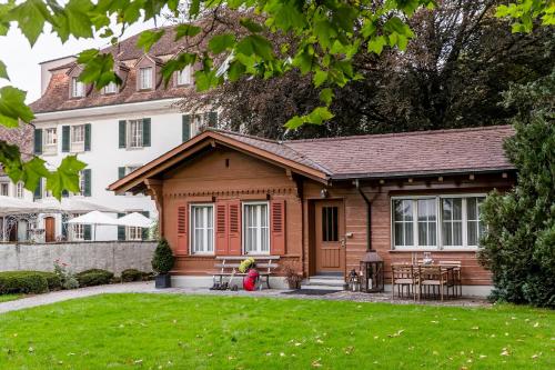 a house with a porch and a yard at Hotel Schloss Hünigen in Konolfingen