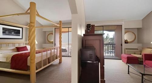 a bedroom with a bed and a living room at Ramada by Wyndham Monument in Monument