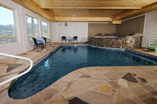 a swimming pool in a house with a table and chairs at Splash N Heavenly Views in Gatlinburg