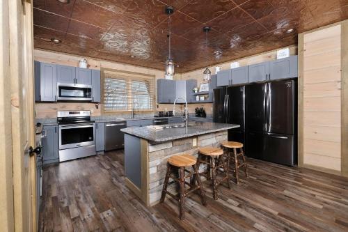 a kitchen with stainless steel appliances and wooden floors at Splash N Heavenly Views in Gatlinburg
