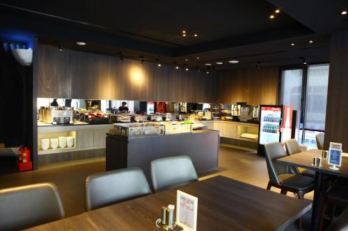 a restaurant with tables and chairs and a kitchen at Hotel Lainn in Kaohsiung