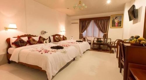 a hotel room with two beds and a table at Asia Hotel in Phnom Penh