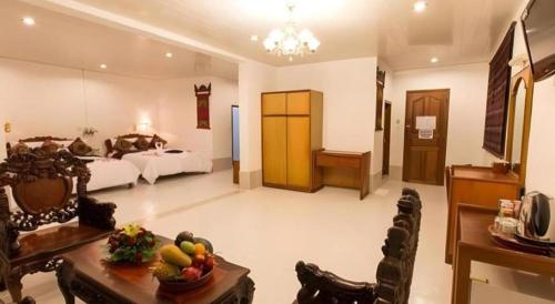 a large room with two beds and a table with fruit on it at Asia Hotel in Phnom Penh