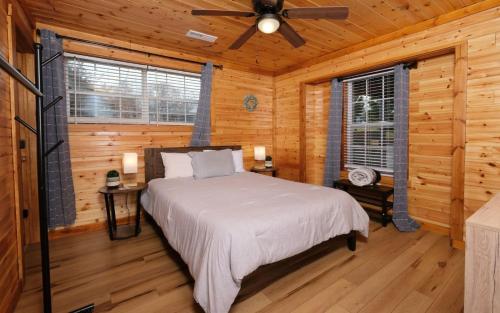 une chambre avec un lit dans une cabane en rondins dans l'établissement The Sunrise House, à Sevierville
