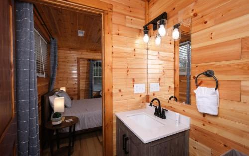 La salle de bains est pourvue d'un lavabo et d'un lit dans la chambre. dans l'établissement The Sunrise House, à Sevierville