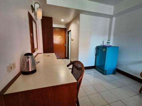 a kitchen with a counter and a blue refrigerator at Naza Orchid Pattaya in Pattaya South