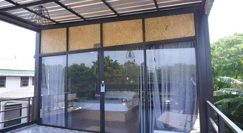 a screened in porch with a view of a pool at Near beach hostel in Bang Tao Beach