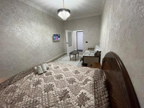 a bedroom with a bed with a quilt on it at ЖК Prime park in Shymkent