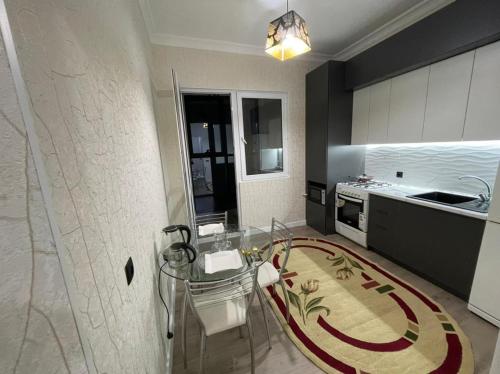 a kitchen with a glass table and a counter at ЖК Prime park in Shymkent