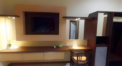 Cette chambre dispose d'un bureau et d'une télévision murale. dans l'établissement Hotel Khalista, à Gurungsang