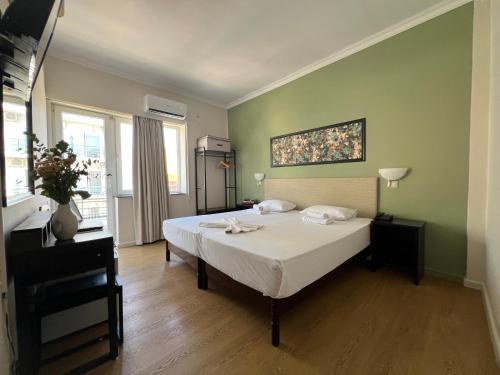 a bedroom with a large white bed in a room at Grand Hotel Loutraki in Loutraki