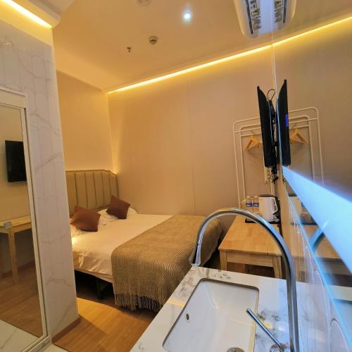 a room with a bed and a bathroom with a sink at 上海璞逸酒店-豫园 新天地 老西门地铁站店 in Shanghai