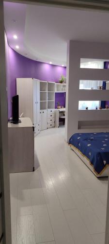 a bedroom with a bed and a purple wall at уют in Dobrovelychkivka