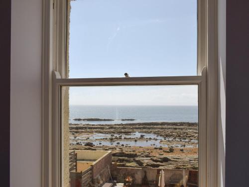 a window with a view of the ocean at The Fisherman's Loft in Cellardyke