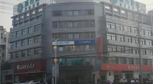 a large building on the corner of a city street at City Comfort Inn Dangtu High Speed East Railway Station RT-Mart in Ma'anshan