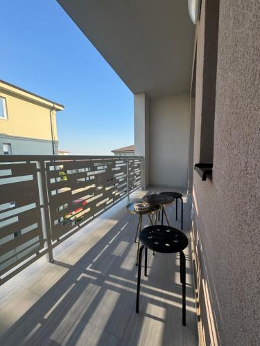 蒂米什瓦拉Milo Residence的阳台上摆放着两张凳子，可以欣赏美景