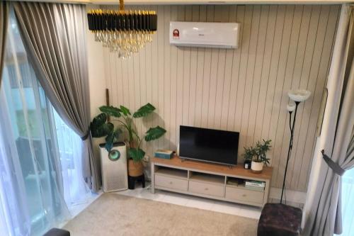 a living room with a tv on a stand with plants at Iris 32 3BR Corner Lot Wi-fi Mutiara Rini Skudai JB Malay Only in Johor Bahru
