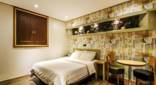 a bedroom with a bed and a table with chairs at Seven Motel Ansan in Ansan