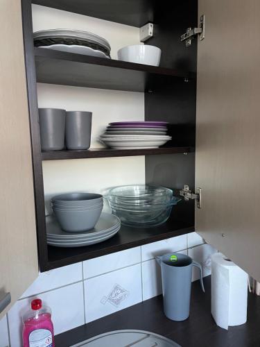 a kitchen cabinet with plates and bowls and dishes at Paulo in Golenice