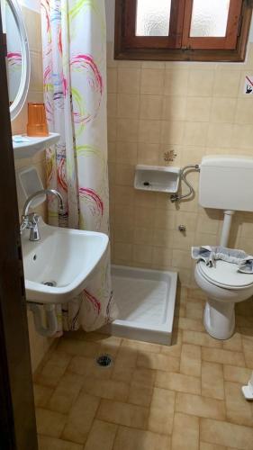a bathroom with a sink and a toilet and a shower curtain at Rooms Lemonakia Beach in Kokkari