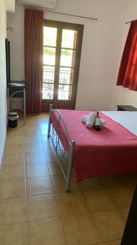a bedroom with a red bed with a red blanket at Rooms Lemonakia Beach in Kokkari