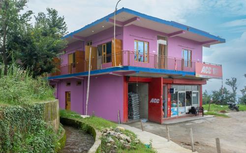 een roze huis met een balkon erop bij Nature's View Kandwari in Pālampur