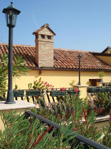 a yellow building with a brick chimney and a street light at Locanda Modigliani in Ferrara