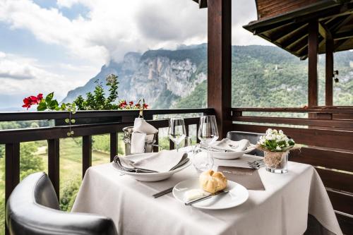 a table with a white table cloth and wine glasses at Hotel Arcobaleno in Fai della Paganella