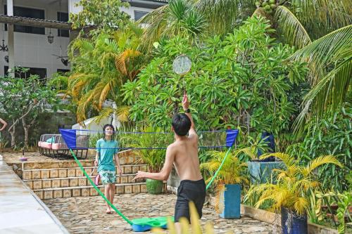 two boys playing with a ball in a pool at 9 Bedroom Villa Mui Ne With Private Pool in Mui Ne