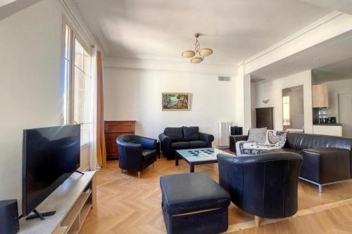 un salon avec un canapé et une télévision dans l'établissement Bright air-conditioned flat in the city centre, à Nice