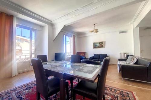 un salon avec une table, des chaises et un canapé dans l'établissement Bright air-conditioned flat in the city centre, à Nice