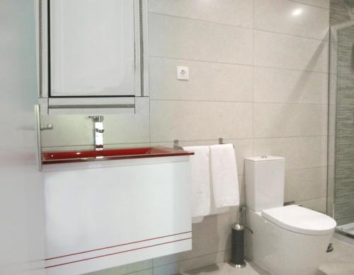 a white bathroom with a toilet and a sink at Equinaturi in Santo Tirso