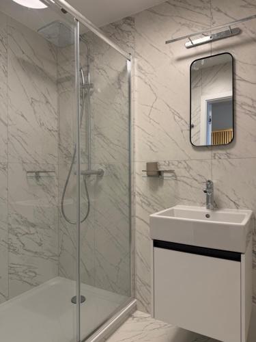 ein weißes Badezimmer mit Dusche und Waschbecken in der Unterkunft Luxapartments - Lake View Apartment 202 in Penati Golf Resort in Šajdíkove Humence