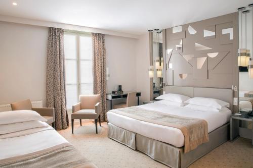 a hotel room with two beds and a desk at Hôtel A La Villa des Artistes in Paris