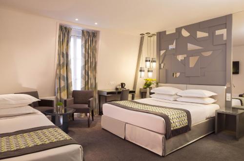 a hotel room with two beds and a desk at Hôtel A La Villa des Artistes in Paris