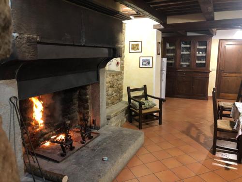 a fireplace in a living room with a fire at Farmhouse in Apecchio with Swimming Pool, Terrace, Garden in Apecchio