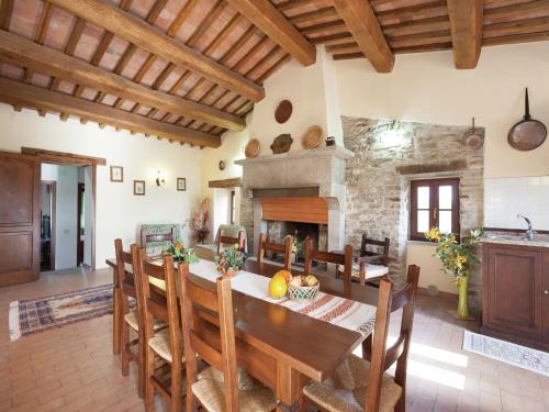 a kitchen and dining room with a table and a fireplace at Farmhouse in Apecchio with Swimming Pool, Terrace, Garden in Apecchio