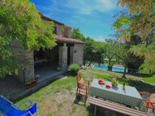 a house with a table and chairs in the yard at Farmhouse in Apecchio with Swimming Pool, Terrace, Garden in Apecchio