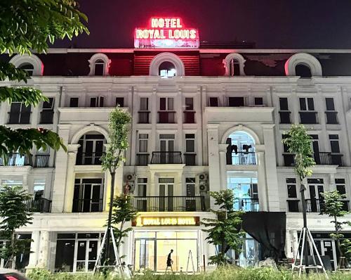 a building with a neon sign on top of it at Royal Louis Hotel in Dai Mo